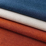 Tissus décoratifs empilés en trois couleurs élégantes : bleu marine, blanc cassé et orange rouille. Idéal pour la décoration intérieure ou la confection de vêtements. Ces tissus offrent une palette de couleurs riches et chaleureuses pour tout projet créatif.