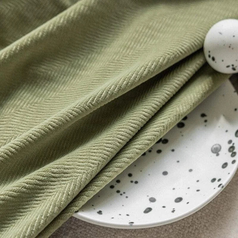 Serviette vert clair avec motif géométrique élégamment posée sur une assiette blanche au design à motifs noirs. Accessoire décoratif idéal pour un intérieur moderne et sophistiqué, ajoutant une touche de style et de raffinement à votre table. Parfait pour une décoration de table unique et contemporaine.
