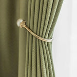 Attache-rideau élégante en métal doré avec rideau vert, idéale pour ajouter une touche sophistiquée à votre décoration intérieure, tout en optimisant la gestion de la lumière dans vos pièces.