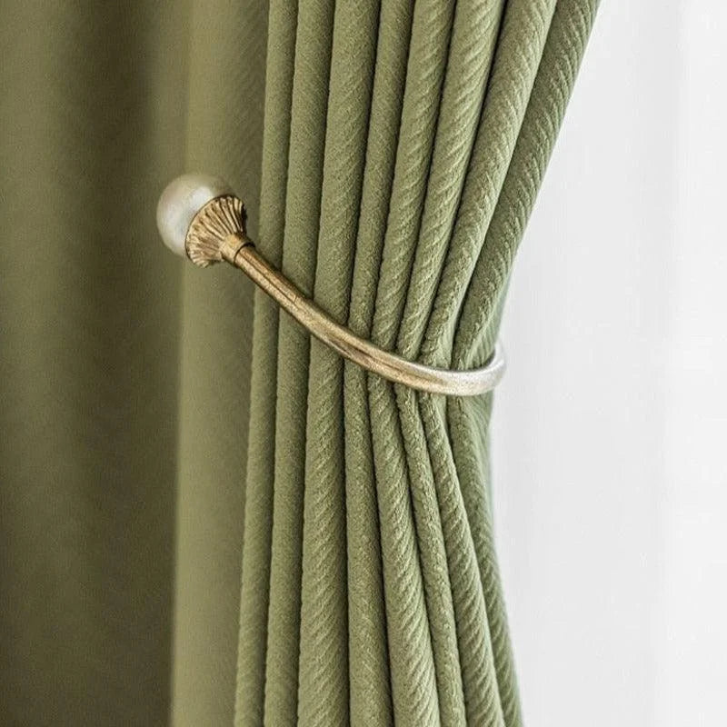 Attache-rideau élégante en métal doré avec rideau vert, idéale pour ajouter une touche sophistiquée à votre décoration intérieure, tout en optimisant la gestion de la lumière dans vos pièces.