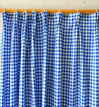 Rideau à carreaux bleus et blancs, idéal pour ajouter une touche de charme rustique à votre intérieur. Accessoire décoratif parfait pour la cuisine ou le salon, ce rideau offre un style intemporel tout en apportant de la couleur et de l'élégance à votre espace. Adapté à différents types de tringles grâce à ses attaches pratiques.