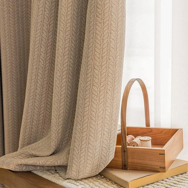 Rideau beige avec motif discret, idéal pour un salon chaleureux. Accessoire de décoration intérieure, offrant une ambiance apaisante et élégante. Bois clair visible à côté pour un style naturel.