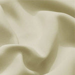 Image d'un textile beige doux drapé en plis élégants, idéal pour la décoration intérieure ou la confection de vêtements chics.