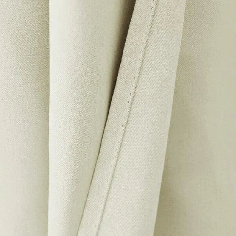 Détail d'un rideau beige avec une couture soignée, idéal pour ajouter une touche d'élégance à votre intérieur. Découvrez ce design sobre et intemporel qui s'intègre parfaitement dans tout style de décoration.