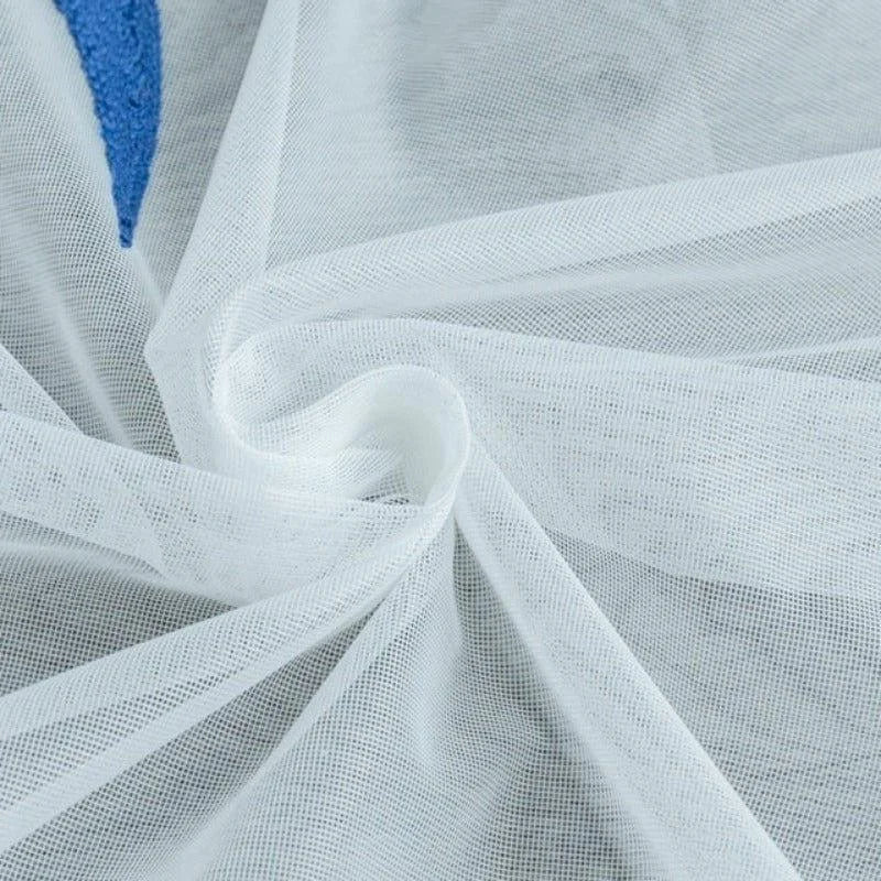 Voile blanc léger et transparent disposé en pli lisse, idéal pour la décoration intérieure ou la confection de vêtements délicats.