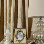 Rideaux élégants avec motif de feuilles en relief, parfaits pour apporter une touche de sophistication à votre intérieur. Complétez la décoration avec une lampe de table au design raffiné, un cadre photo vintage et un photophore décoratif pour une ambiance chaleureuse et accueillante. Idéal pour un salon ou une chambre à coucher.