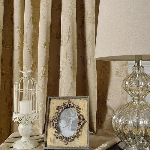 Rideaux élégants avec motif de feuilles en relief, parfaits pour apporter une touche de sophistication à votre intérieur. Complétez la décoration avec une lampe de table au design raffiné, un cadre photo vintage et un photophore décoratif pour une ambiance chaleureuse et accueillante. Idéal pour un salon ou une chambre à coucher.