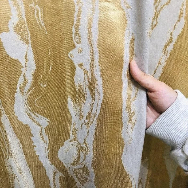 Revêtement mural élégant avec motif marbré doré et crème. Tissu luxueux idéal pour habiller votre intérieur de manière moderne. Parfait pour ajouter une touche de sophistication et de style à n'importe quelle pièce. Design unique et tendance pour une décoration raffinée.