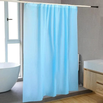 Rideau de douche bleu clair suspendu dans une salle de bain moderne avec baignoire élégante et meubles intégrés en bois clair. Fenêtre permettant une lumière naturelle abondante, créant une ambiance apaisante et lumineuse. Idéal pour ajouter une touche de couleur et de fraîcheur à votre espace.