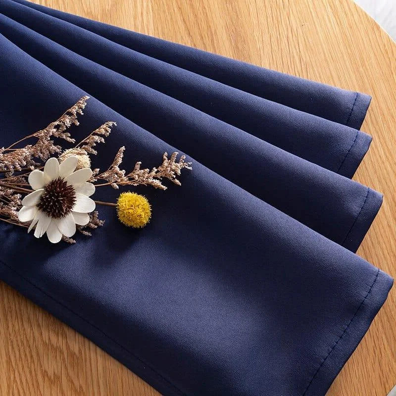 Rideau bleu élégant sur table en bois, idéal pour décoration intérieure. Accessoire de maison tendance avec fleurs décoratives, parfait pour ajouter une touche de style à votre salon ou chambre.
