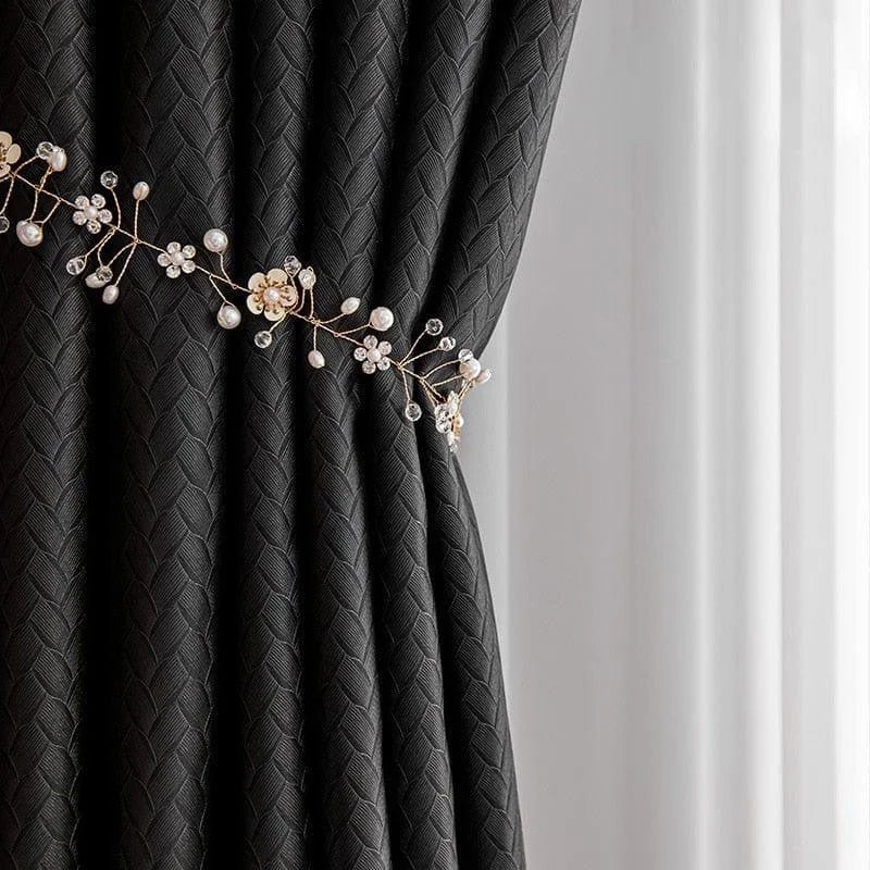 Rideau élégant noir avec motif géométrique, maintenu par un embrasse décoratif en forme de branche florale ornée de perles et de cristaux, ajoutant une touche raffinée et sophistiquée à tout intérieur moderne. Idéal pour salon ou chambre à coucher.