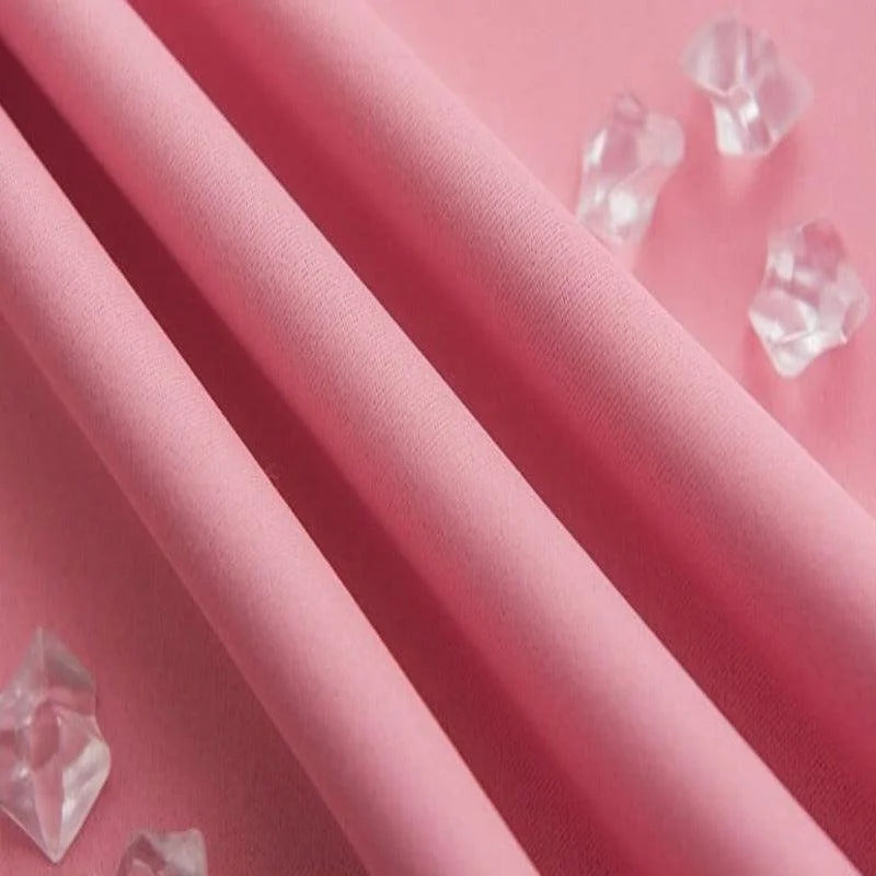 Tissu rose doux soigneusement plié, parfait pour la couture et la décoration, avec un fond élégant et des accents cristallins pour une touche raffinée. Idéal pour des créations uniques et personnalisées.