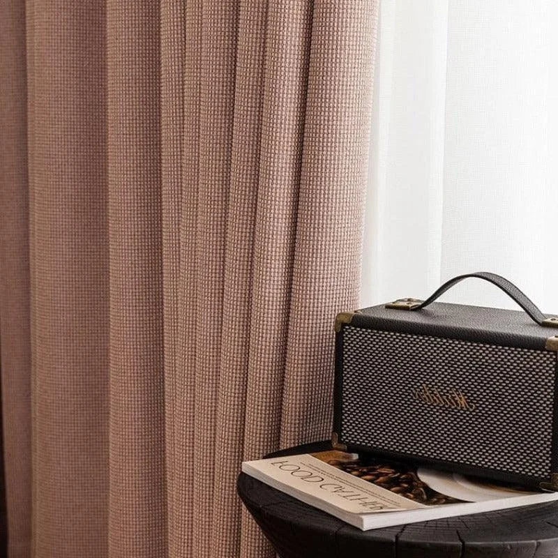 Rideaux élégants de couleur taupe, ajoutant une touche de sophistication à tout intérieur. À droite, une enceinte vintage repose sur une table sombre, accompagnée d'un livre, créant une ambiance cosy et moderne parfaite pour un salon ou une chambre.