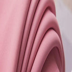 Image montrant un tissu rose drapé élégamment, idéal pour des créations de mode tendance. Ce textile aux plis harmonieux ajoute une touche de douceur et de modernité aux projets de couture et décoration.