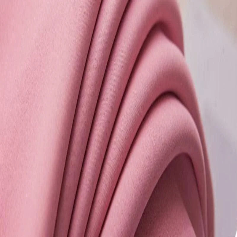 Image montrant un tissu rose drapé élégamment, idéal pour des créations de mode tendance. Ce textile aux plis harmonieux ajoute une touche de douceur et de modernité aux projets de couture et décoration.
