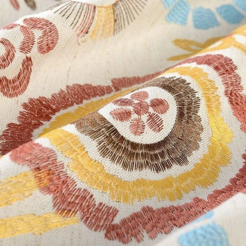 Décoration textile avec motifs géométriques colorés, teintes marron, jaune, et bleu, style bohème pour intérieur moderne et tendance. Idéal pour coussins, rideaux et créations décoratives.