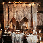 Décoration intérieure bohème avec tenture murale et ambiance lumineuse, idéal pour une atmosphère chaleureuse et élégante, mise en scène avec des bougies et ornements naturels.