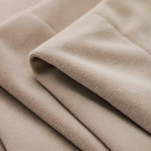 Tissu beige délicat et élégant, parfait pour des créations de mode raffinées et sophistiquées. Idéal pour des vestes, manteaux ou accessoires élégants, ajoutant une touche de luxe à toute garde-robe.