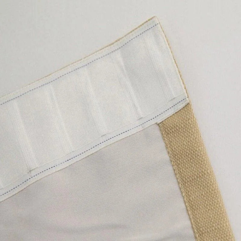 Rideau beige avec bande de renforcement blanche, conçu pour un accrochage facile sur tringle. Accessoire de décoration intérieure, idéal pour bloquer la lumière et ajouter une touche d'élégance à votre espace.