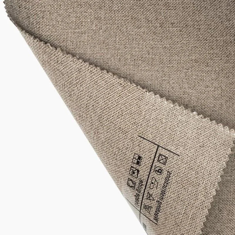 Échantillon de tissu beige avec icônes d'instructions de lavage sur le revers, idéal pour la confection de vêtements ou d'articles de décoration intérieure.質