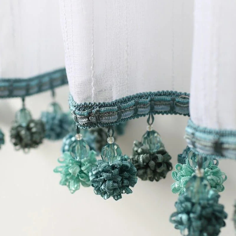 Rideau décoratif élégamment brodé avec pompons bleus, parfait pour ajouter une touche raffinée et esthétique à votre intérieur. Ce modèle de rideau apporte du style à toute pièce tout en filtrant délicatement la lumière. Idéal pour le salon ou la chambre à coucher.