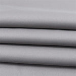 Tissu gris élégant, plié en couches, idéal pour la confection de vêtements sur mesure ou projets de décoration intérieure, offrant un style moderne et intemporel.