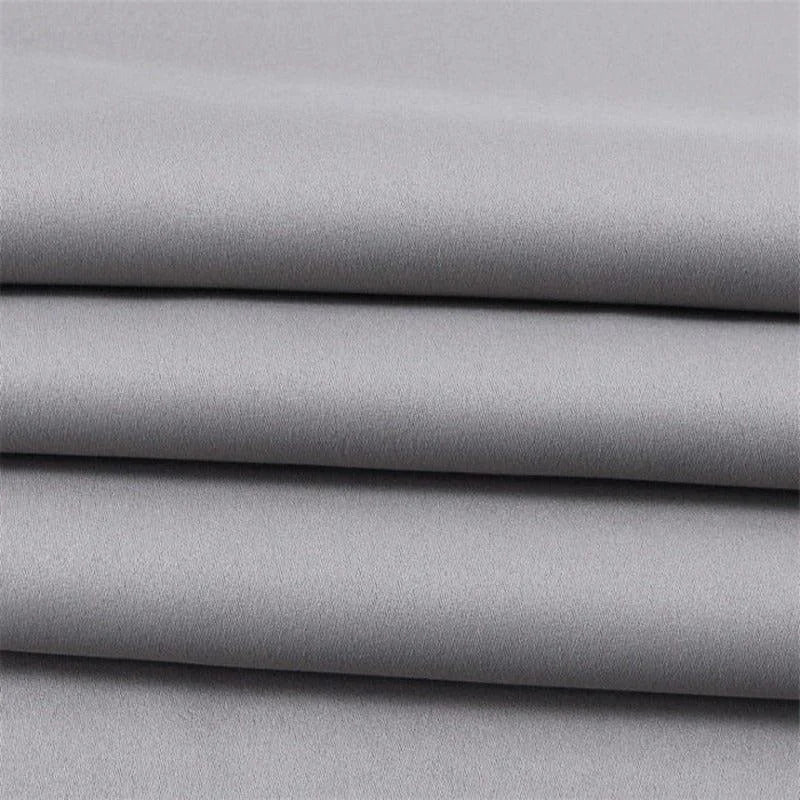 Tissu gris élégant, plié en couches, idéal pour la confection de vêtements sur mesure ou projets de décoration intérieure, offrant un style moderne et intemporel.
