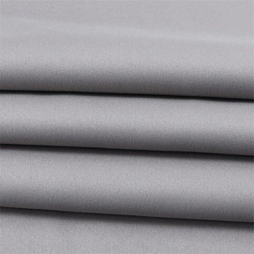 Tissu gris élégant, plié en couches, idéal pour la confection de vêtements sur mesure ou projets de décoration intérieure, offrant un style moderne et intemporel.