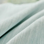 Tissu élégant bleu clair avec une texture subtile et plissée, parfait pour la décoration intérieure moderne ou la confection de vêtements tendance. Idéal pour apporter une touche de sophistication à votre espace de vie ou votre garde-robe.