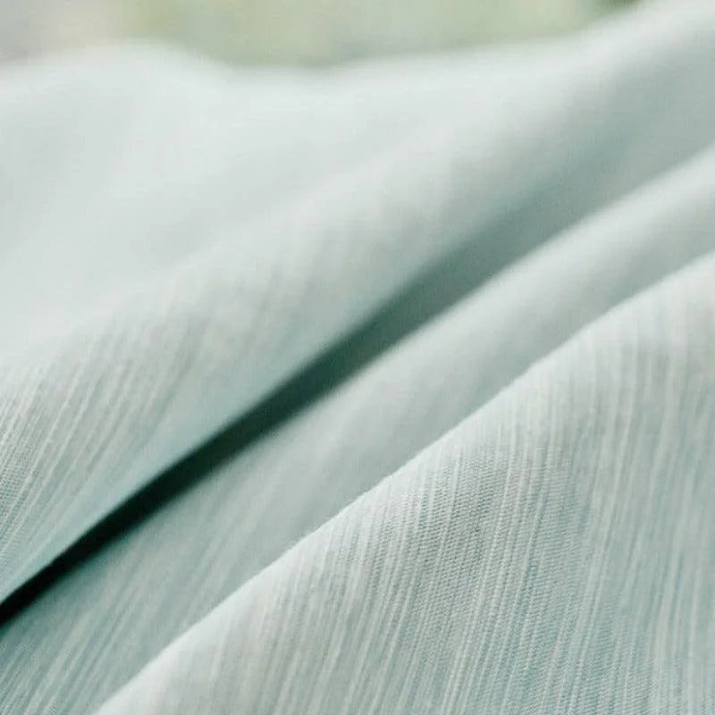 Tissu élégant bleu clair avec une texture subtile et plissée, parfait pour la décoration intérieure moderne ou la confection de vêtements tendance. Idéal pour apporter une touche de sophistication à votre espace de vie ou votre garde-robe.