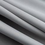 Close-up d'un tissu gris élégant et lisse, idéal pour la confection de vêtements modernes et sophistiqués. Idéal pour créer des tenues chics et durables, parfait pour ceux qui cherchent à allier style et confort avec une touche de raffinement.