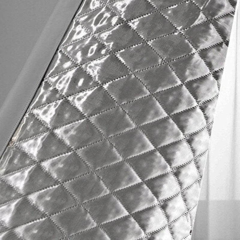 Image montrant une surface matelassée argentée avec un motif géométrique en losanges, parfaite pour ajouter une touche de modernité et d'élégance dans une décoration intérieure contemporaine. Adaptée pour des usages variés tels que des revêtements muraux ou des accessoires de décoration, cette texture réfléchissante apporte une ambiance sophistiquée et lumineuse à n'importe quel espace.