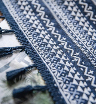Chemin de table élégant avec motifs géométriques, de couleur bleue et blanche, agrémenté de franges décoratives. Idéal pour embellir une salle à manger avec une touche d'élégance et de style moderne. Parfait pour des occasions spéciales ou l'usage quotidien, ajoutant une dimension esthétique à votre intérieur.