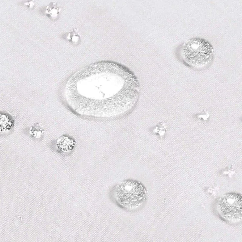 Gouttes d'eau sur un tissu blanc, illustrant l'effet déperlant efficace et moderne, idéal pour une protection contre l'humidité et les liquides. Solution parfaite pour les environnements nécessitant une surface facile à entretenir tout en garantissant un aspect propre et net.