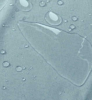 Gros plan sur un tissu résistant à l'eau, mettant en évidence des gouttelettes d'eau en surface, illustrant son imperméabilité idéale pour les vêtements et accessoires extérieurs.