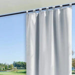 Rideau blanc élégant suspendu devant une grande fenêtre, offrant une vue panoramique sur un paysage verdoyant. Solution idéale pour embellir et illuminer votre intérieur tout en préservant votre intimité. Idéal pour salon ou chambre à coucher.