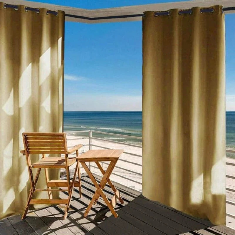 Rideaux occultants beige pour terrasse avec vue sur la mer, offrant une protection solaire optimale et créant une ambiance extérieure élégante. Aménagement de balcon avec mobilier en bois pour un espace détente confortable au bord de l'eau.