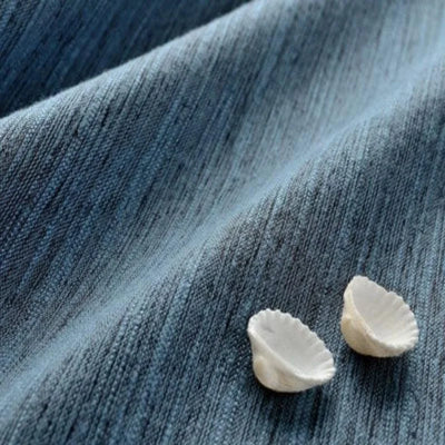 Tissu bleu ondulé avec de petites coquilles décoratives blanches. Parfait pour la décoration intérieure ou les projets de couture créatifs. Visuellement apaisant, idéal pour ajouter une touche marine et élégante à tout espace.
