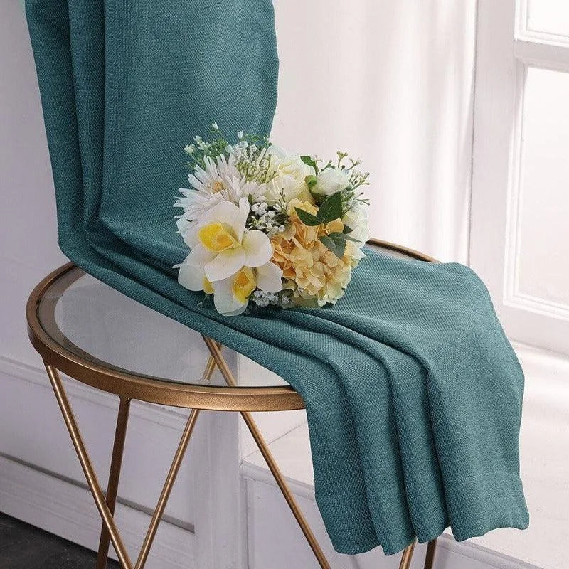 Élégante couverture de couleur verte drapée sur une table design en verre doré, accentuée par un bouquet de fleurs blanches et jaunes, idéale pour ajouter une touche de sophistication à votre intérieur. Accessoire décoratif parfait pour le salon ou la chambre, offrant style et raffinement.