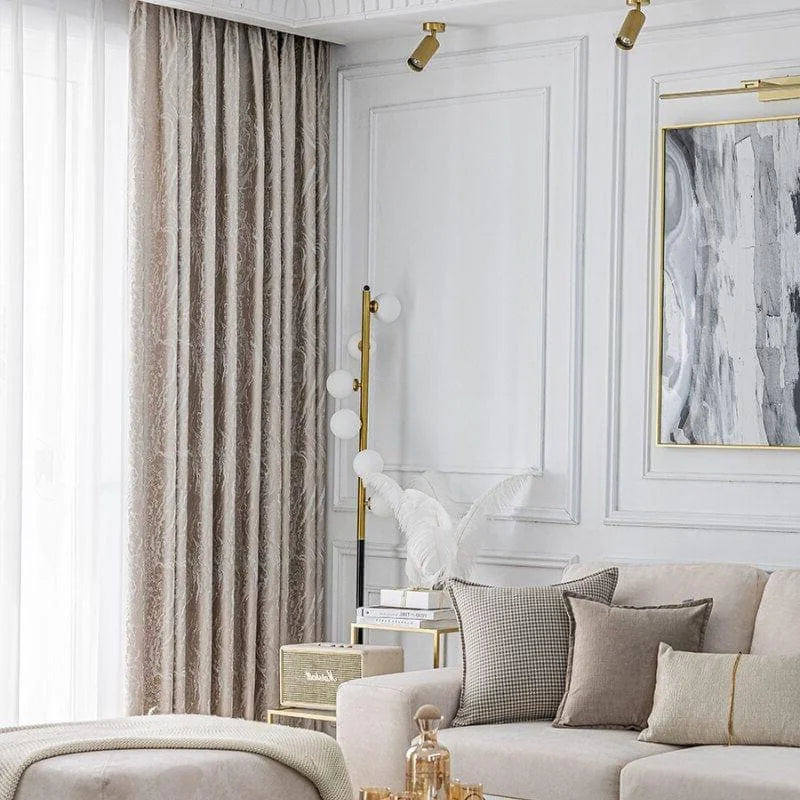 Salon moderne et élégant avec rideaux beiges, canapé confortable agrémenté de coussins assortis, lampadaire design et décoration murale en harmonie. Espace lumineux et accueillant, idéal pour une ambiance chaleureuse et raffinée.