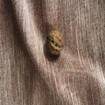 Gros plan sur une décoration élégante avec une texture striée marron et un détail naturel en forme de noix, parfait pour rehausser l'esthétique intérieure de votre salon ou chambre.