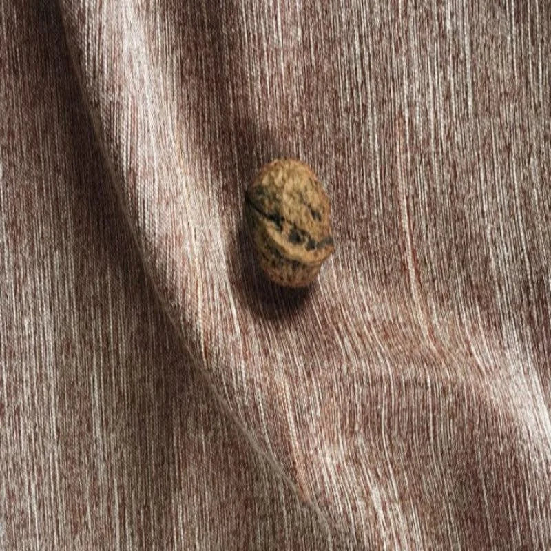 Gros plan sur une décoration élégante avec une texture striée marron et un détail naturel en forme de noix, parfait pour rehausser l'esthétique intérieure de votre salon ou chambre.