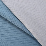 Tissu bleu et gris avec motif géométrique chevrons, idéal pour décoration ou ameublement intérieur moderne. Parfait pour ajouter une touche d'élégance et de sophistication à tout espace de vie.