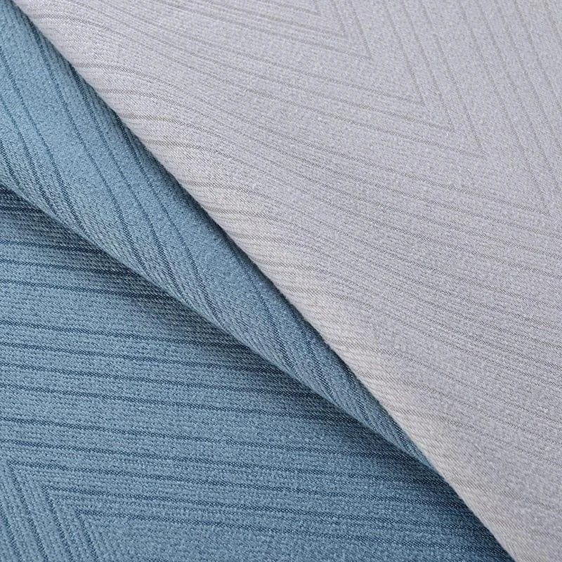 Tissu bleu et gris avec motif géométrique chevrons, idéal pour décoration ou ameublement intérieur moderne. Parfait pour ajouter une touche d'élégance et de sophistication à tout espace de vie.