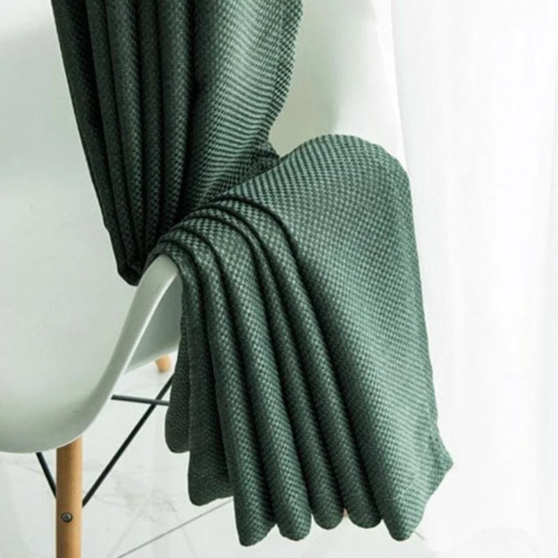 Plaid vert foncé drapé sur une chaise moderne, ajoutant une touche élégante à la décoration intérieure. Ce plaid est idéal pour apporter chaleur et style à votre salon ou chambre à coucher. Son design raffiné s'intègre parfaitement dans un cadre contemporain. Parfait pour se détendre lors des soirées fraîches.