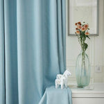 Rideaux bleu doux pour décoration intérieure, idéal pour votre salon ou chambre. Apportez une touche d'élégance avec ces rideaux élégants, complétés par un vase élégant contenant des fleurs fraîchement coupées. Transformez votre espace de vie avec style et sophistication.
