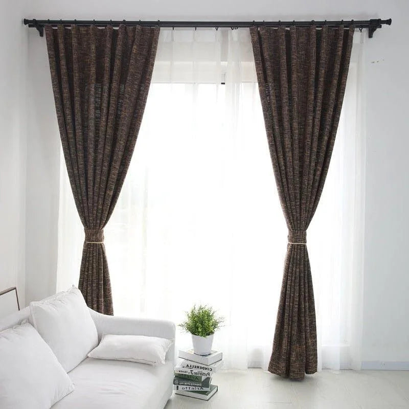 Rideaux élégants de couleur sombre, accentuant un salon moderne et lumineux, avec un canapé blanc confortable et une plante décorative sur une table basse, offrant une ambiance chaleureuse et accueillante.