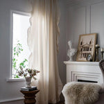 Rideaux élégants de couleur claire dans un salon raffiné avec cheminée blanche et décoration artistique, créant une ambiance chaleureuse et sophistiquée. Convient parfaitement pour un intérieur classique et élégant.