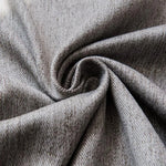 Gros plan sur un tissu gris, parfaitement drapé pour mettre en valeur sa texture. Le design élégant et raffiné souligne la qualité supérieure du produit, idéal pour l'habillement ou la décoration intérieure.