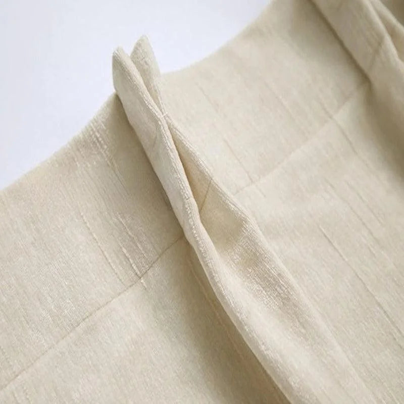 Pantalon élégant pour femme en beige, coupe classique avec détails soignés. Idéal pour un look raffiné au bureau ou pour des occasions spéciales. Facile à assortir avec des hauts de différentes couleurs pour un style polyvalent.
